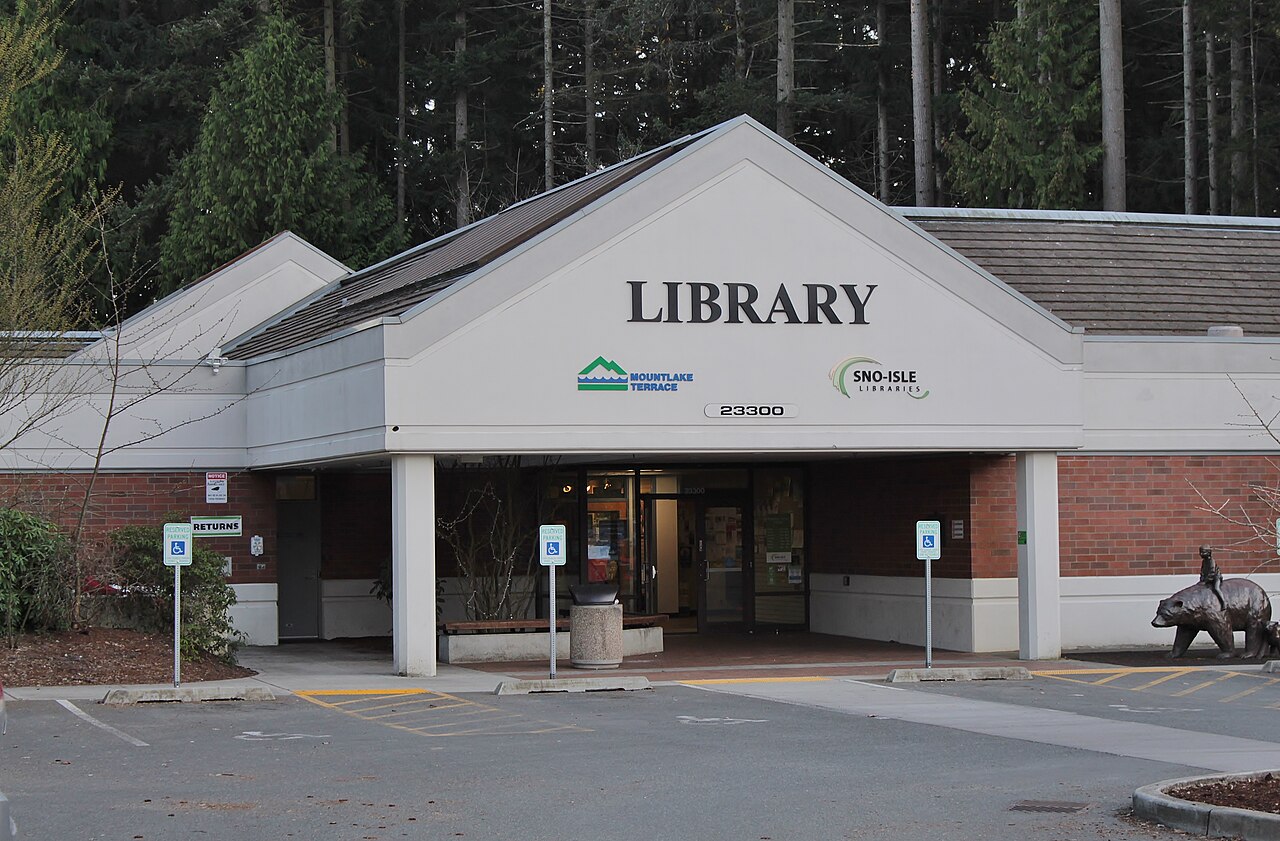 Mountlake Terrace Library and its entrance beneath tall evergreen trees