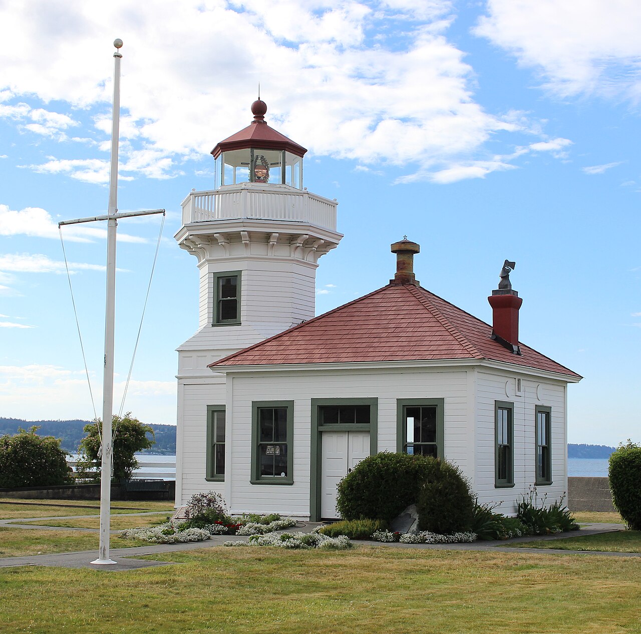 The Mukilteo Lighthouse beside the waterfront under a blue sky
