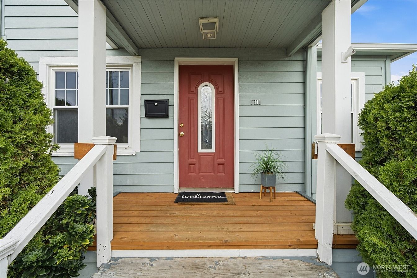 Covered front porch with a red entry door