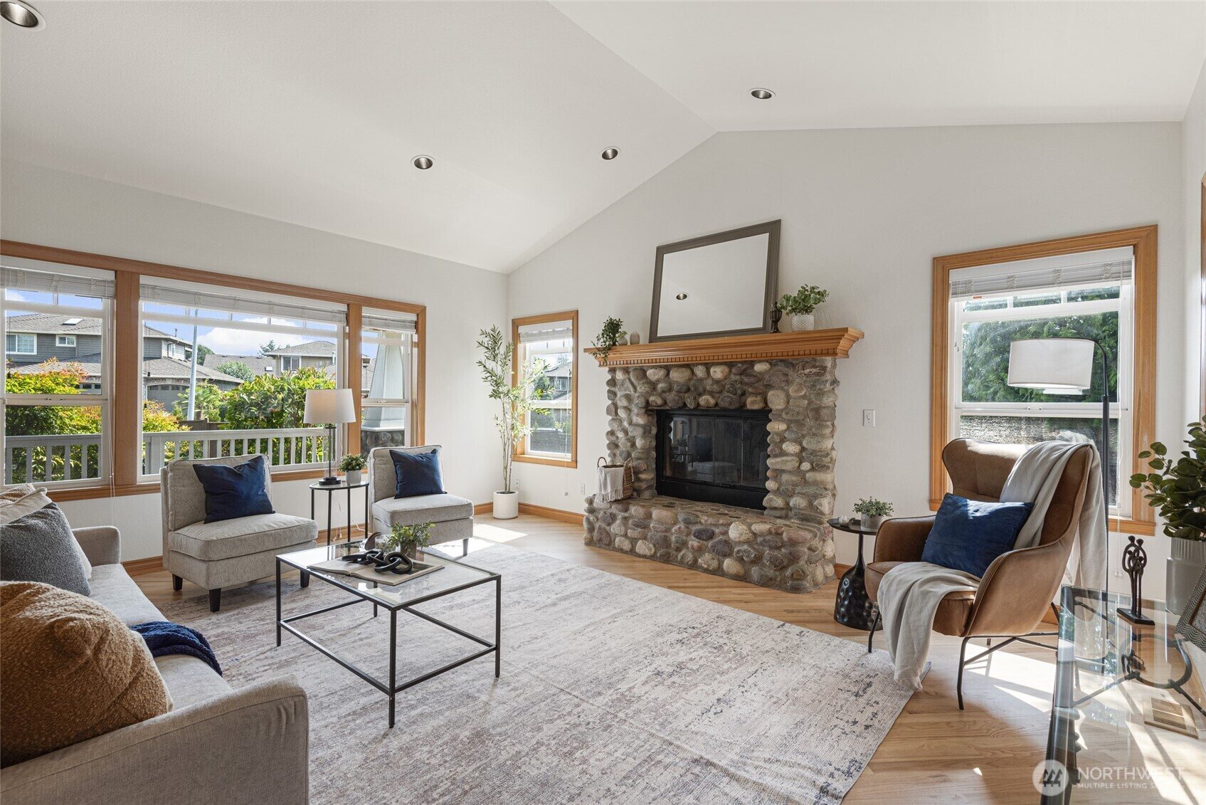Living room with stone fireplace and large windows