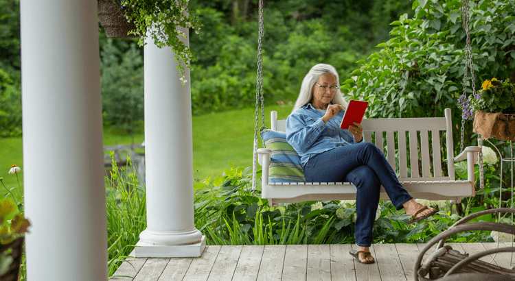 A prospective homebuyer reading on the porch of a home