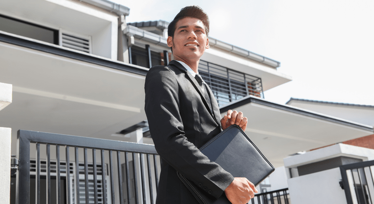 Real estate professional standing in front of a modern home